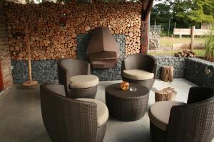 un patio con sillas de mimbre y una hoguera en Domaine de Carnin en Beloeil