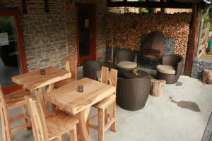 un patio con mesas y sillas de madera y chimenea en Domaine de Carnin, en Beloeil