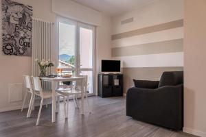 sala de estar con mesa y sofá en Maison Bibi Lago Maggiore, en Laveno-Mombello