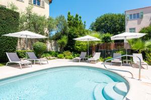 a swimming pool with chairs and umbrellas at Mas Djoliba in Antibes