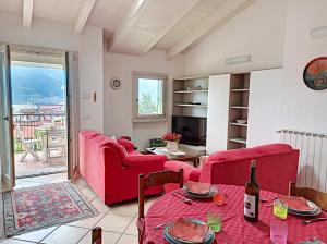 Una sala de estar con sillas rojas y una mesa. en Feel at Home - CASA SOFIA, en Lovere