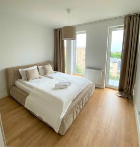 uma cama grande num quarto com uma janela grande em Luxury Port View - BillBerry Apartments em Gdynia