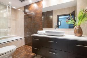 Un baño con lavabo, inodoro y ducha. en Mira Agua Villa, en Vasilikos 28 fotos más