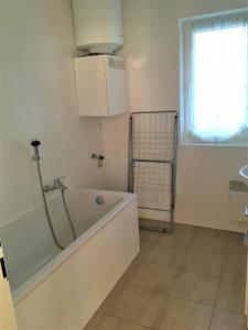 a white bath tub in a bathroom with a window at Lipno - Seepark Residence in Horní Planá