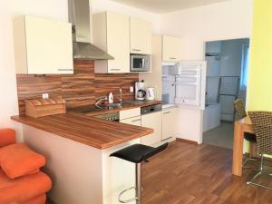 a kitchen with white cabinets and a counter top at Lipno - Seepark Residence in Horní Planá