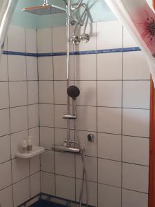 a shower in a bathroom with white tiles at Nireas : Stone Villa in Zakynthos