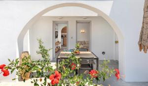 Alafropetra Luxury Suites في أكروتيري: ممر يؤدي إلى مطبخ مع الزهور الحمراء