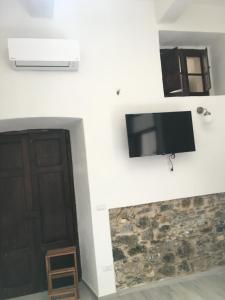 a flat screen tv on a wall next to a door at casa vacanze Rose Marie in Capitello
