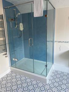 a shower with a glass enclosure in a bathroom at Fox and Hounds Apartment in Willingham