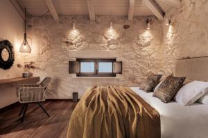 Un dormitorio con una cama y una pared de piedra. en Mira Agua Villa, en Vasilikos