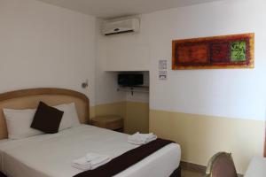 D'Cesar Hotel Acapulco في أكابولكو: غرفة فندق عليها سرير وفوط