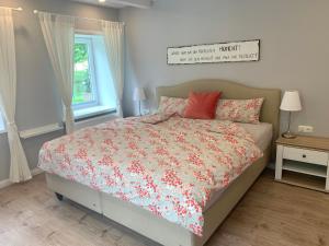 ein Schlafzimmer mit einem Bett mit roten Kissen in der Unterkunft Ferienwohnung Landfein in Quarnstedt