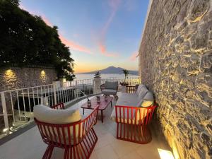 patio z krzesłami i stołem na balkonie w obiekcie Relais Manfredi w mieście Castellammare di Stabia
