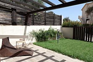 芡歐的住宿－DomoMea - Villetta dell'Agave，天井设有长凳和桌子,位于草地上