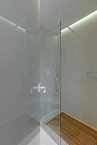 a bathroom with a shower with a glass door at Boho Sapiens, Cinnamon Era in Adamantas