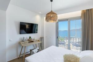 a bedroom with a bed and a view of the ocean at Boho Sapiens Marina - Cinnamon Era in Adamas