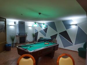 a living room with a pool table and chairs at Willa Jarzębina in Duszniki Zdrój