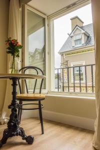 une table et une chaise devant une fenêtre dans l'établissement Rookery Lane Food and Lodging, à Kenmare