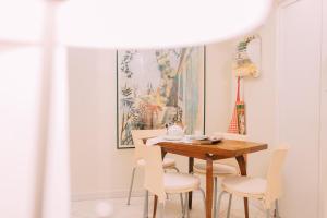 トリノにあるB&B delle Volteのダイニングルーム(木製テーブル、白い椅子付)