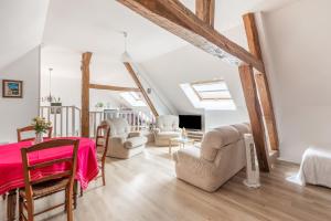 a living room with a bed and chairs in a attic at Gîte Moulin de Pilate 