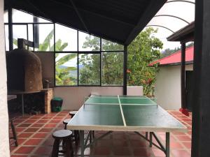 a ping pong table sitting in a room with windows at Estancia los pinos in Jenesano