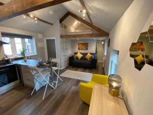 uma cozinha e sala de estar com um sofá e uma mesa em Apartment @ Bastion Mews em Hereford