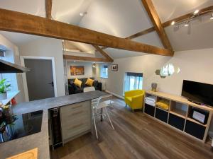 eine Küche im Loft und ein Wohnzimmer mit freiliegenden Holzbalken in der Unterkunft Apartment @ Bastion Mews in Hereford