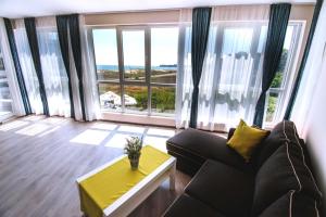 a living room with a couch and large windows at Donchevi Apartments in Primorsko