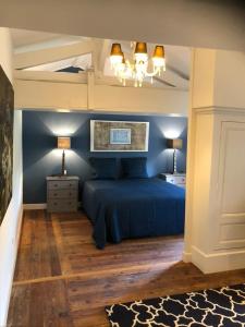 een slaapkamer met een blauw bed en 2 lampen bij Domaine en Reynouse in Pierreclos