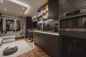 a kitchen with black cabinets and a counter at Sunset Apartment in Pomorie