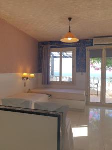 1 dormitorio con 2 camas y ventana en Korifi Apts & Std Adults Only en Hersonissos