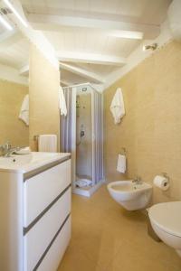 a bathroom with two sinks and a toilet and a shower at Il Falconiere in Muravera