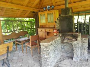 a patio with a stone fireplace and a table at Ranczo pod Babią Górą in Lipnica Wielka