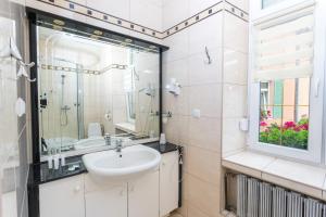 a bathroom with a sink and a mirror at Hotel Wenecki in Częstochowa