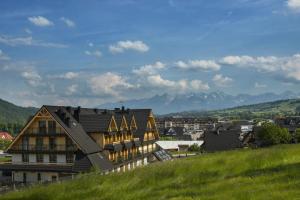 a house on a hill with mountains in the background at Askana in Białka Tatrzańska