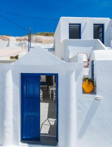 a blue door on the side of a white building at Blue Moon Villa in Imerovigli