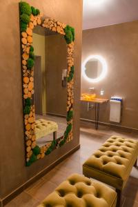ein Spiegel in einem Raum mit einer Bank und einem Tisch in der Unterkunft Hotel Dastan in Levice + 87 Fotos