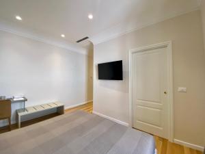 Zimmer mit einem Bett und einem TV an der Wand in der Unterkunft Residenza d'epoca dei Fondachi in Sarzana