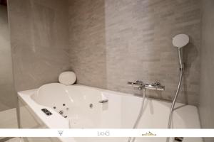 a white bath tub with a shower in a bathroom at Marmotte 205 - Splendide duplex aux pieds des pistes in Bonneval-sur-Arc +11 photos