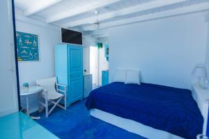 a blue bedroom with a blue bed and a desk at Blue Moon Villa in Imerovigli