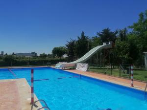 a large swimming pool with a slide in a yard at Camping Cubillas in Cubillas de Santa Marta