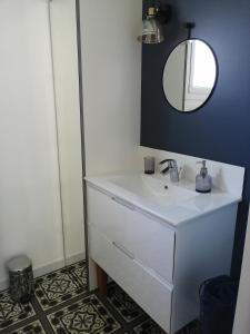 ein Badezimmer mit einem weißen Waschbecken und einem Spiegel in der Unterkunft VILLA XARAN ERDIAN Gîte LA PETITE MAISON in Espelette