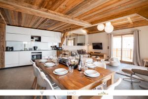 cocina y sala de estar con mesa de madera y sillas en Marmotte 205 - Splendide duplex aux pieds des pistes en Bonneval-sur-Arc