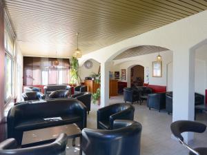 une salle d'attente avec des chaises et des tables en cuir noir dans l'établissement U Libecciu, à Macinaggio