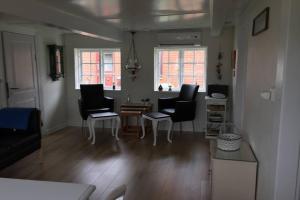 a living room with chairs and a table at Gammelt Mandø hus Hyggebo in Ribe