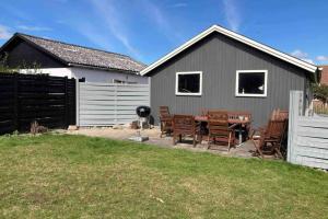 a backyard with a table and chairs and a house at Gammelt Mandø hus Hyggebo in Ribe