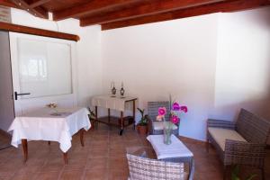 Habitación con mesa, sillas y piano en Il Falconiere, en Muravera