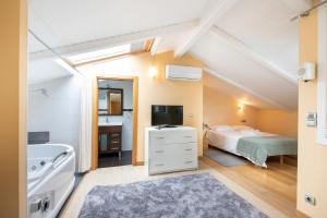 a attic bedroom with a bed and a bathroom at LUXURY DUPLEX PENTHOUSE WITH TERRACE-OLD TOWN in Donostia-San Sebastián