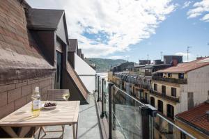 a balcony with a table and a glass of wine at LUXURY DUPLEX PENTHOUSE WITH TERRACE-OLD TOWN in Donostia-San Sebastián