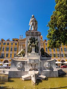 a statue of a man standing on top of a fountain at Aparthotel AMMI Vieux Nice in Nice